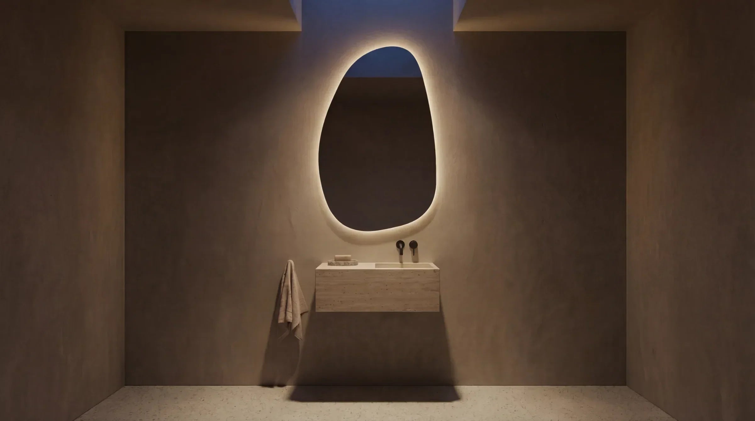 STONE organic asymmetric mirror with a warm LED halo in a modern bathroom. Belgian glass. Claris Company.