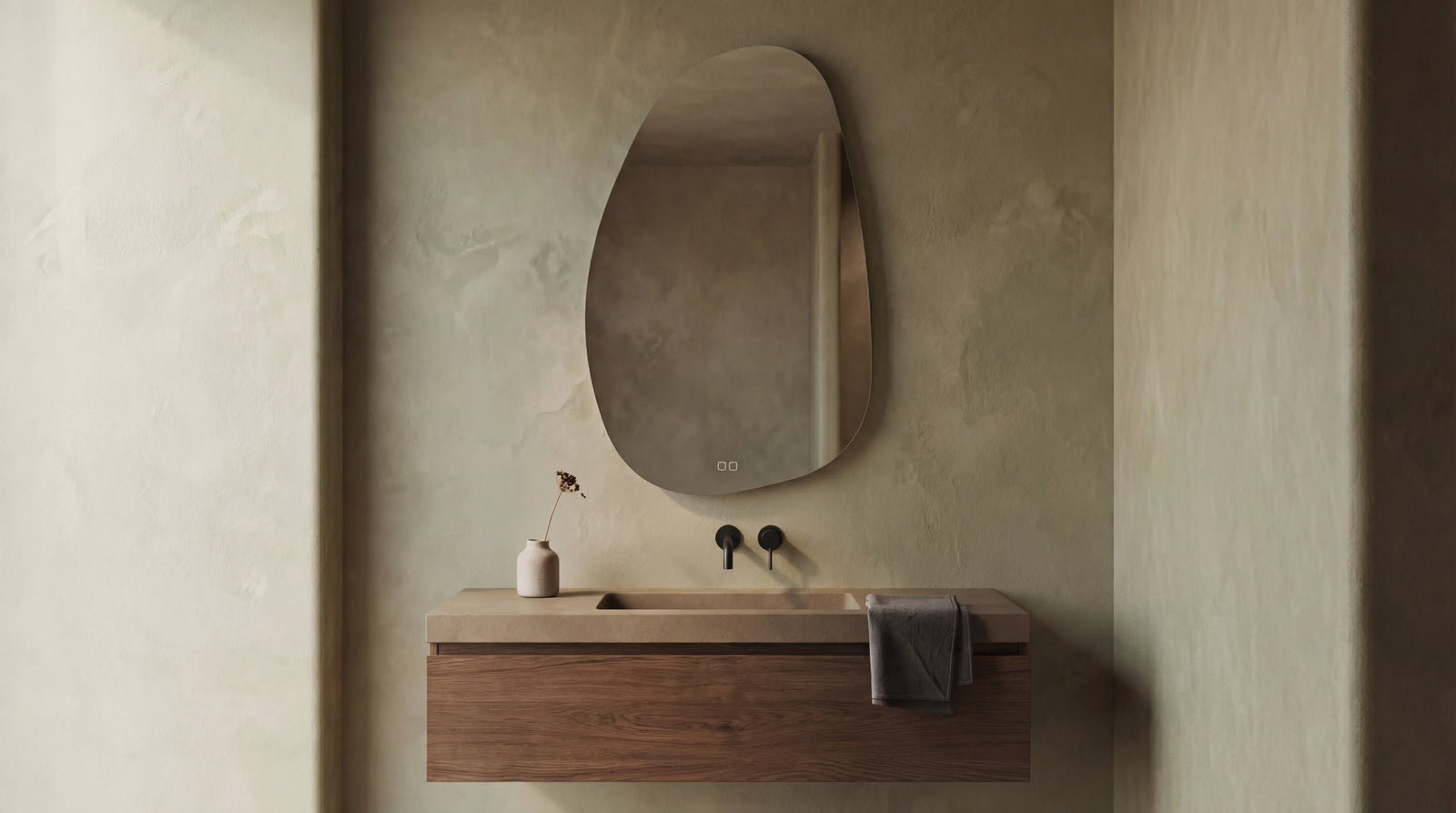 STONE Terra mirror in a sculptural backlit bathroom installation. Organic asymmetric form.