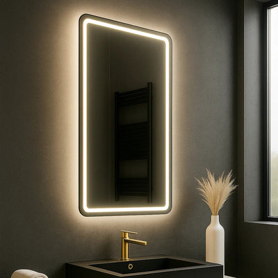 Modern bathroom vanity with illuminated mirror, black sink, and decorative elements.