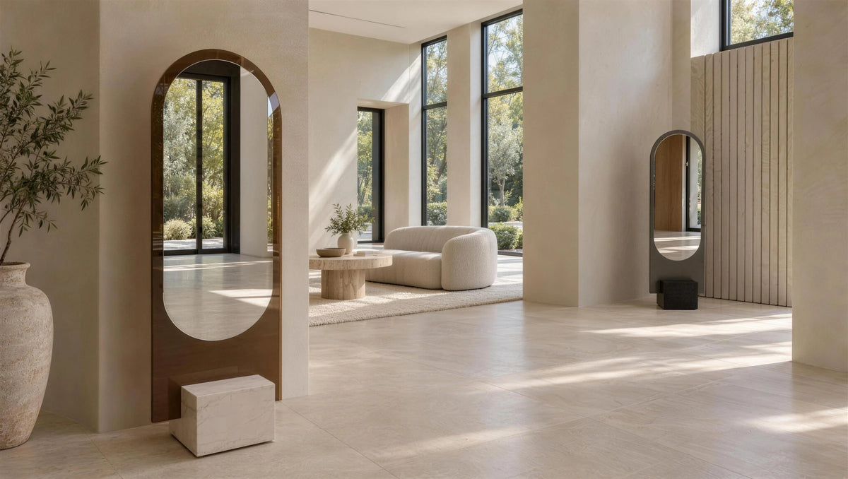 Two Claris ALICE floor mirrors on ĒCLOS Ivora bases in a tall-windowed living room, daylight, wide view