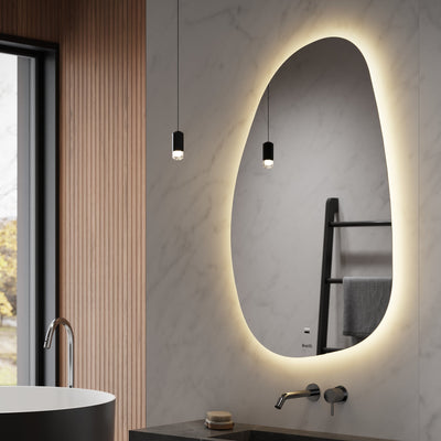 Modern bathroom with a black freestanding bathtub, sink, and illuminated mirror.